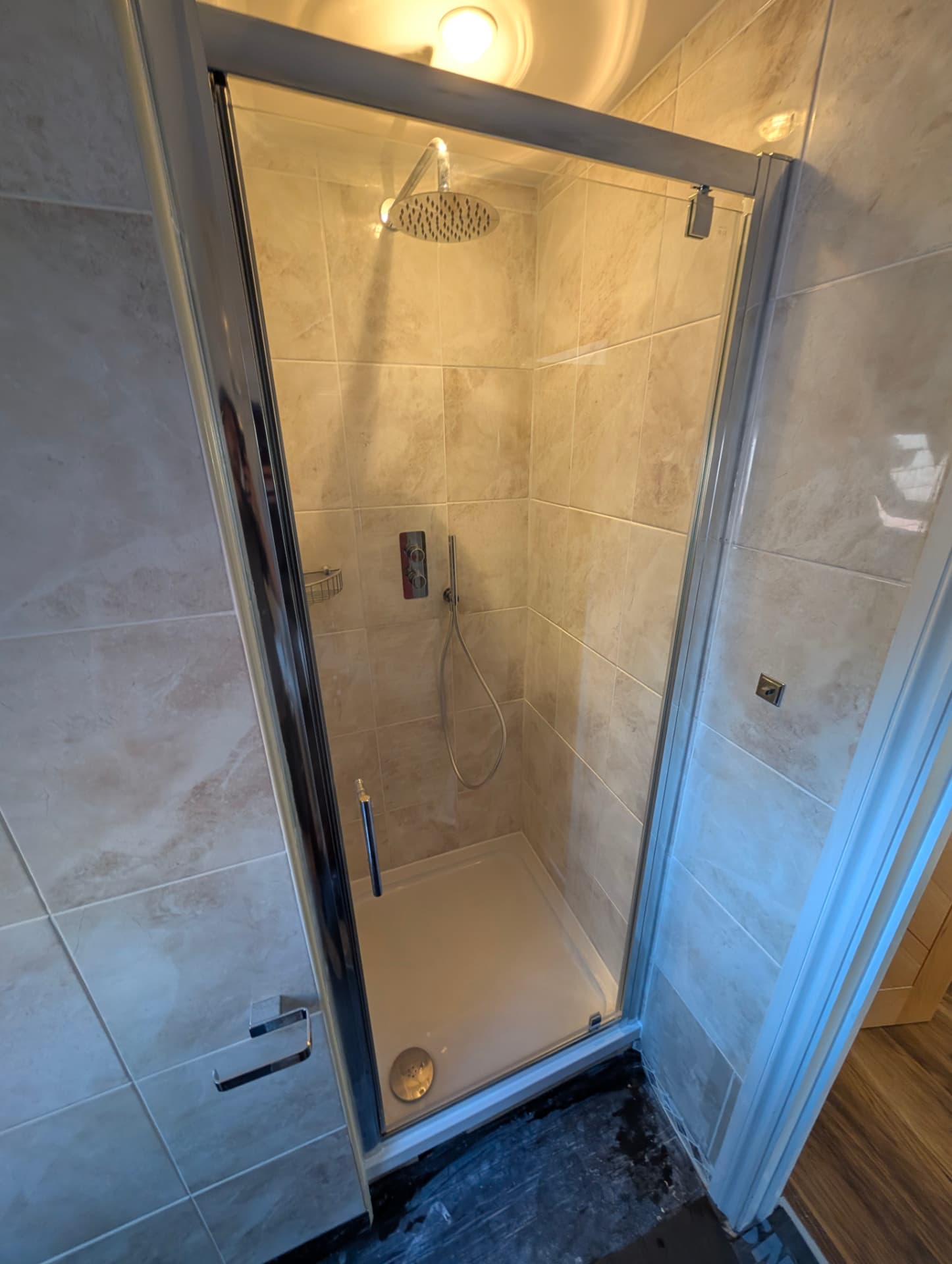 Tiled shower enclosure with pivot door installed in a West Sussex home Tiled shower enclosure with pivot door installed in a West Sussex home